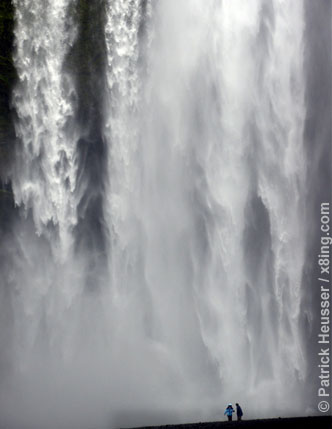 people look tiny in front of the skogafoss waterfall